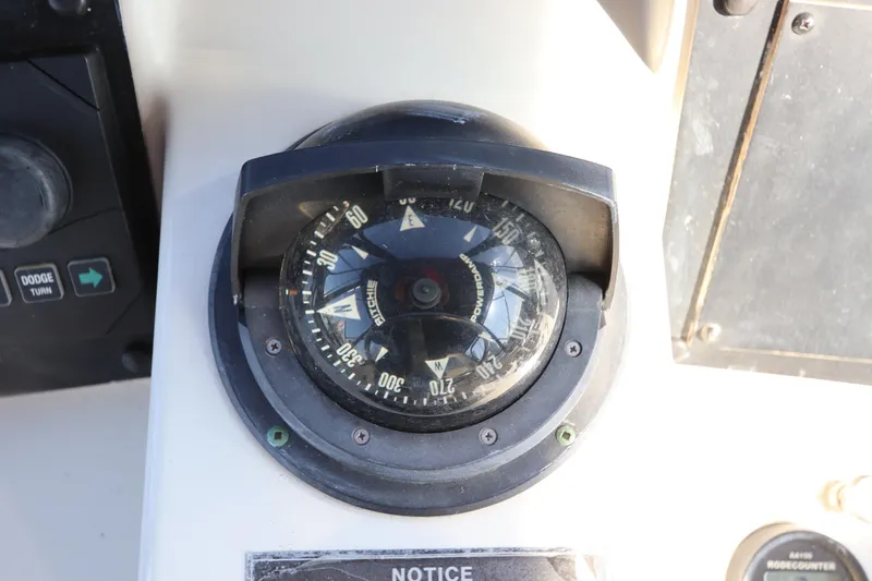 Slide: The Image of Compass on 1990 Hatteras 40 Double Cabin boat dashboard. - 26