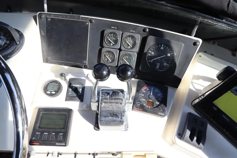 Slide: The Image of Control panel of a 1990 Hatteras 40 Double Cabin yacht with gauges and throttle levers. - 27