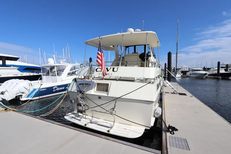 Slide: The Image of 1990 Hatteras 40 Double Cabin yacht docked at marina with American flag. - 3