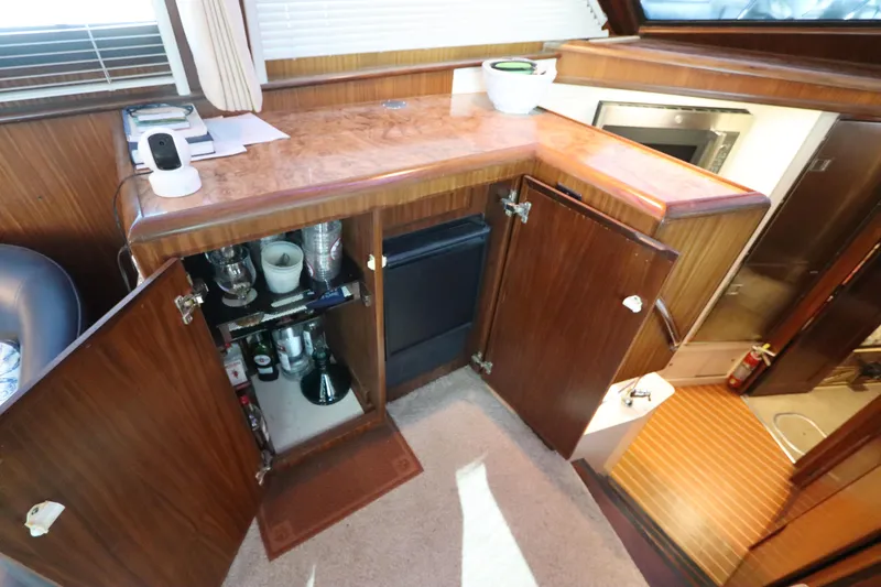 Slide: The Image of Interior of 1990 Hatteras 40 Double Cabin with open cabinets and bar setup. - 33