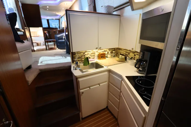 Slide: The Image of Compact kitchen in a 1990 Hatteras 40 Double Cabin yacht, featuring modern appliances and cozy design. - 38