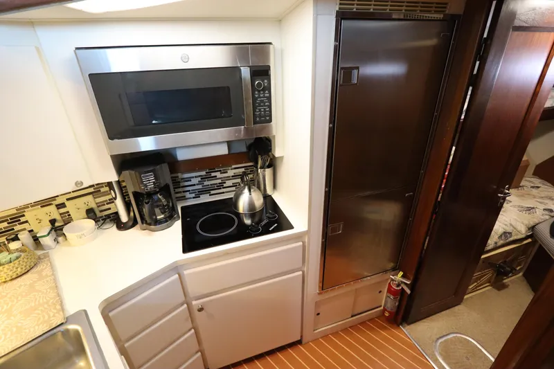 Slide: The Image of Compact kitchen in a 1990 Hatteras 40 Double Cabin yacht with modern appliances. - 39