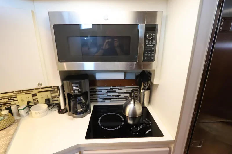 Slide: The Image of Kitchen area in 1990 Hatteras 40 Double Cabin with microwave, stovetop, and coffee maker. - 40