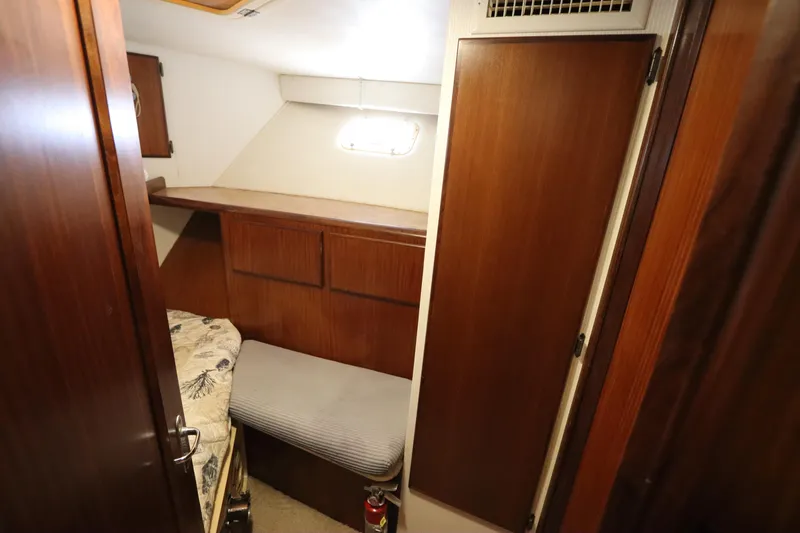 Slide: The Image of 1990 Hatteras 40 Double Cabin interior with wood paneling and cozy sleeping area. - 46