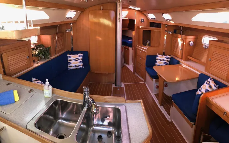 Slide: The Image of Interior of a 2006 Catalina 36 MkII sailboat with blue seating and wooden finishes. - 1