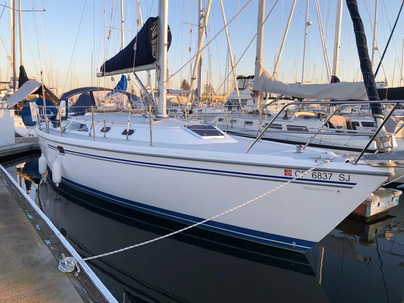 Slide: The Image of 2006 Catalina 36 MkII sailboat docked in a marina, featuring sleek white hull and blue accents. - 11