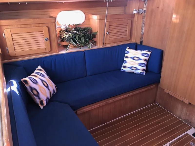 Slide: The Image of Interior of 2006 Catalina 36 MkII sailboat with blue cushions and wooden cabinetry. - 2
