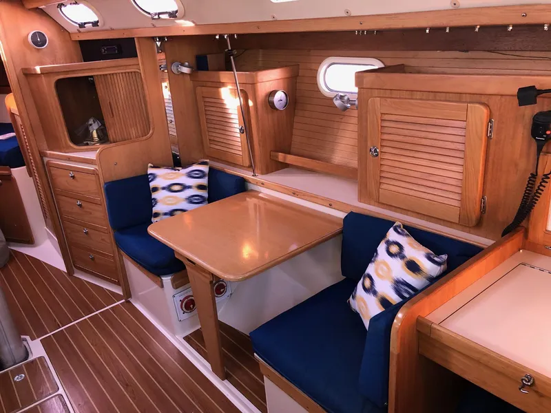 Slide: The Image of Interior of 2006 Catalina 36 MkII sailboat with wooden cabinetry and blue cushioned seating. - 3