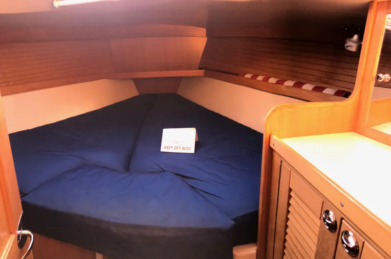 Slide: The Image of 2006 Catalina 36 MkII cabin interior with blue bedding and wooden cabinetry. - 6
