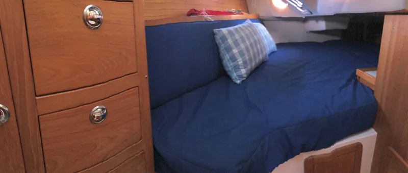 Slide: The Image of Cozy cabin interior of 2006 Catalina 36 MkII with blue bedding and wooden drawers. - 8