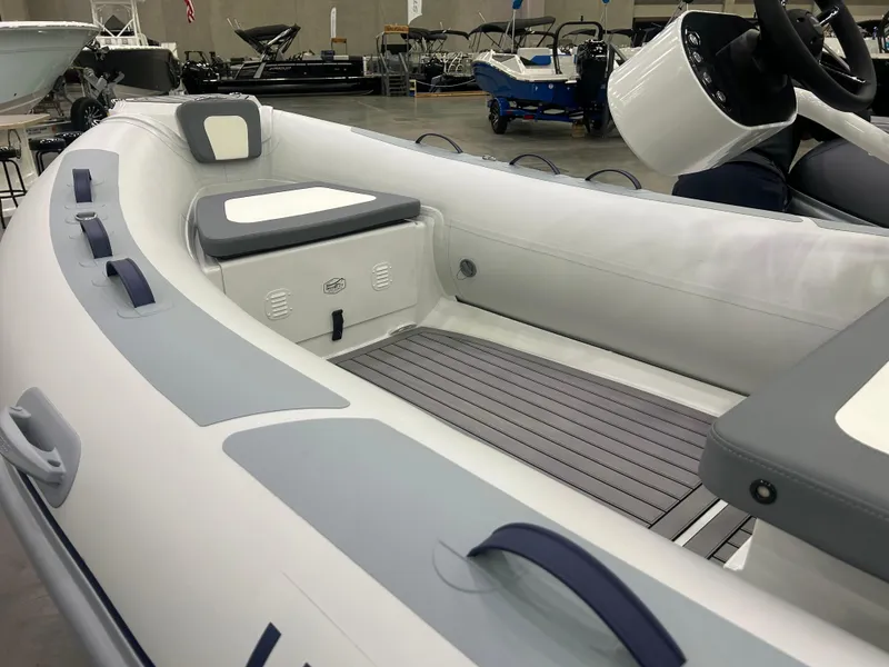 Slide: The Image of 2025 Highfield Classic 400 inflatable boat interior with seating and storage, displayed in a showroom. - 6