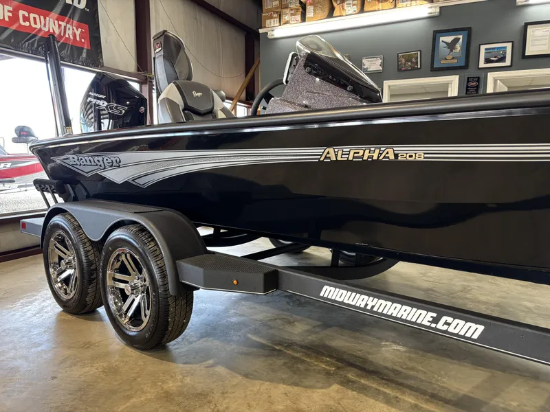 Slide: The Image of 2025 Ranger ALPHA 208 boat on trailer in showroom, featuring sleek black design. - 2