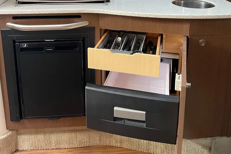 Slide: The Image of Kitchen area of 2014 Sea Ray 330 Sundancer with open drawers and mini fridge. - 11