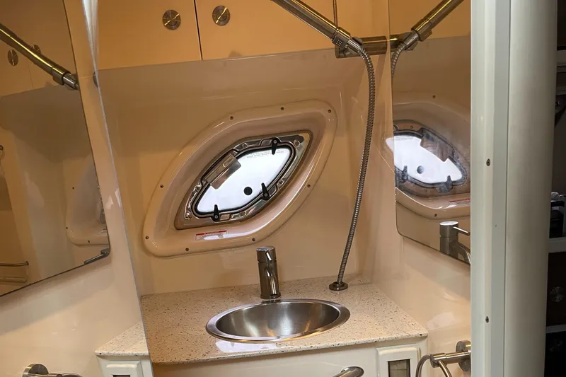 Slide: The Image of 2014 Sea Ray 330 Sundancer bathroom with sink and porthole window. - 16