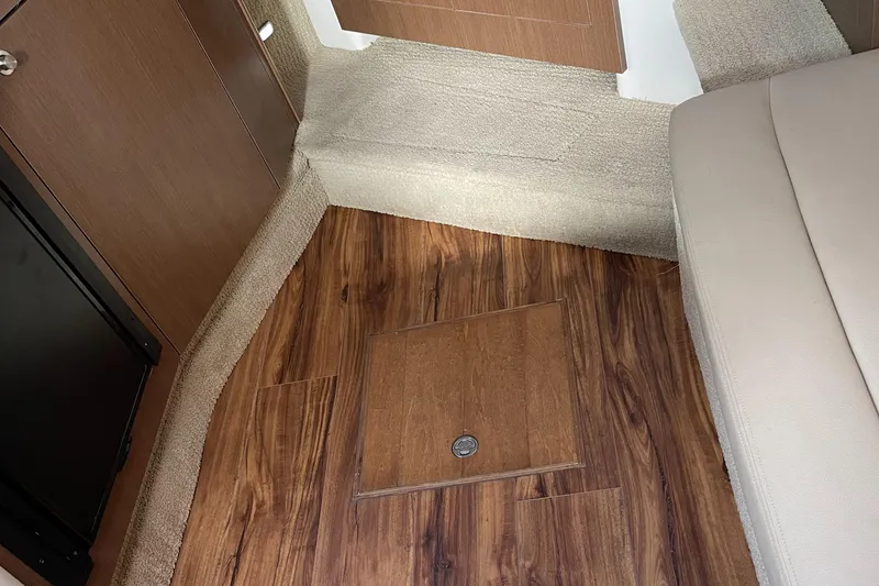 Slide: The Image of Interior of 2014 Sea Ray 330 Sundancer with wood flooring and beige upholstery. - 20