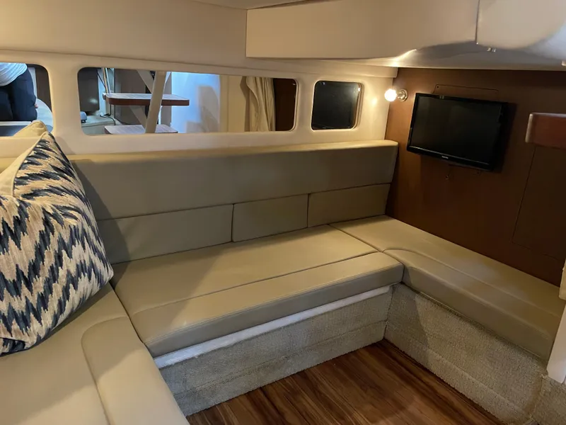 Slide: The Image of Interior of 2014 Sea Ray 330 Sundancer with beige seating and wall-mounted TV. - 21