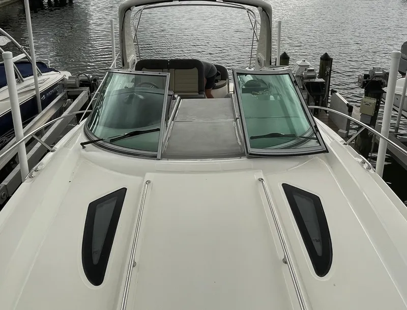 Slide: The Image of 2014 Sea Ray 330 Sundancer boat docked, featuring sleek design and spacious deck. - 24