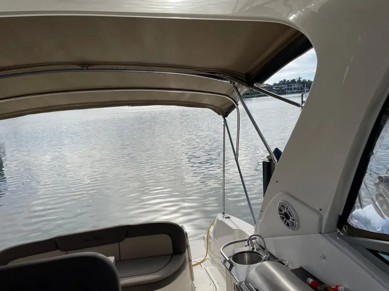 Slide: The Image of 2014 Sea Ray 330 Sundancer interior with water view, featuring seating and canopy. - 3
