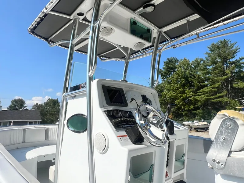 Slide: The Image of 2005 Triumph 23 Center Console boat with steering wheel and control panel. - 7