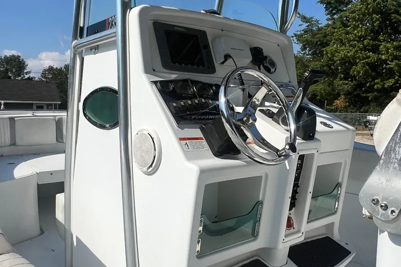Slide: The Image of 2005 Triumph 23 Center Console boat dashboard with steering wheel and controls. - 8