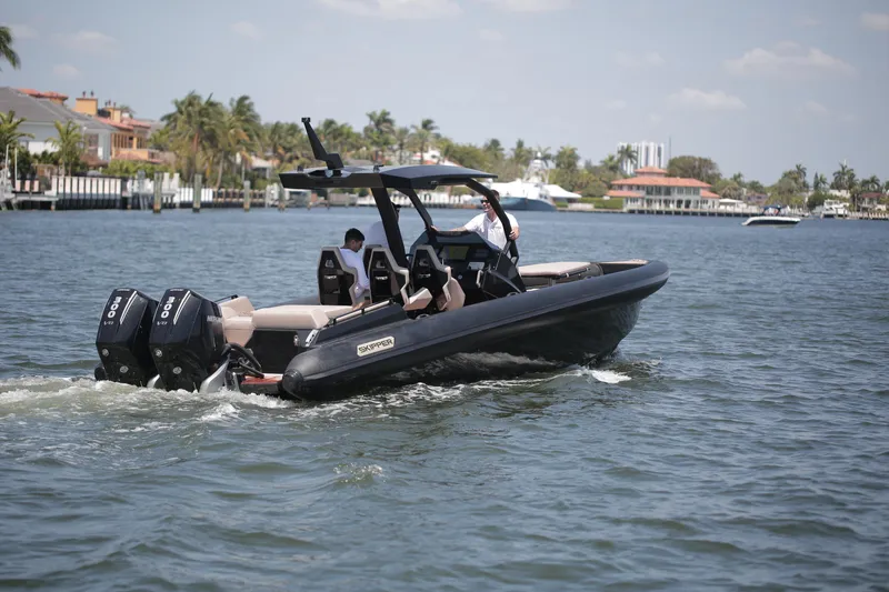 Slide: The Image of 2025 Skipper-BSK 34 boat cruising on a sunny day in a coastal area. - 0