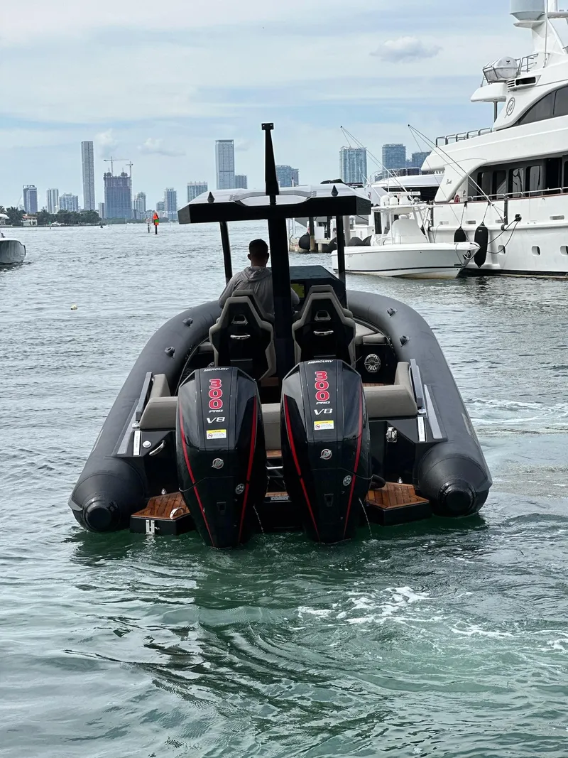 Slide: The Image of 2025 Skipper-BSK 34 boat with dual engines on water, city skyline in background. - 12