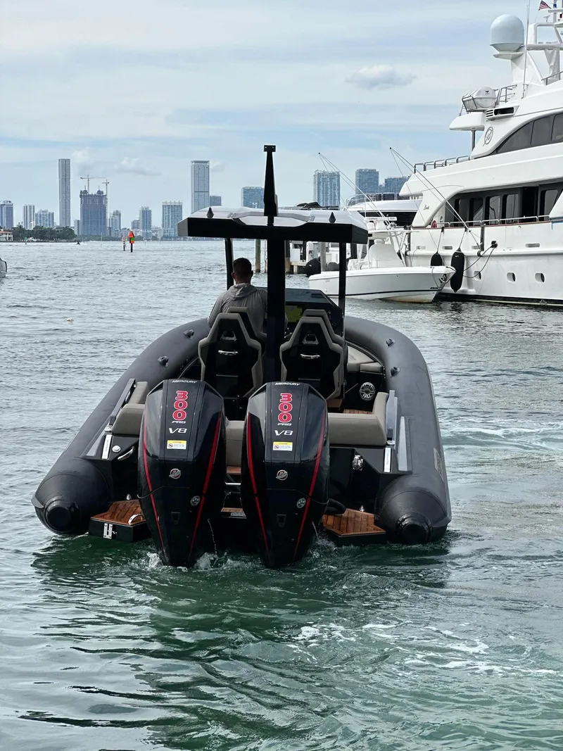 Slide: The Image of 2025 Skipper-BSK 34 boat with dual engines on water, city skyline in background. - 2