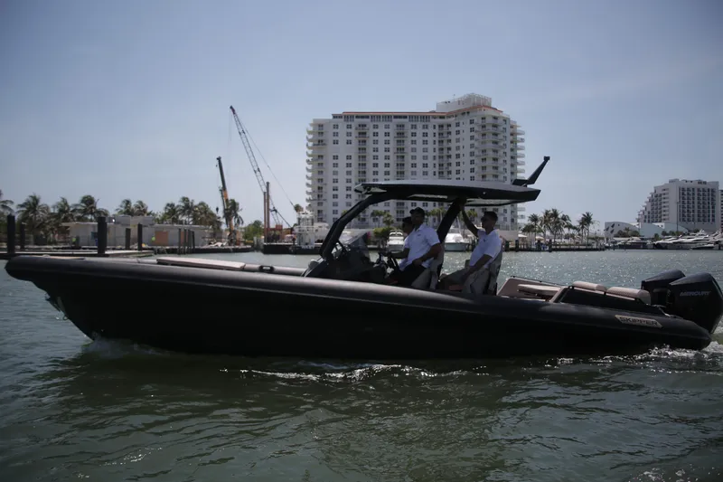 Slide: The Image of 2025 Skipper-BSK 34 boat cruising near urban waterfront with modern buildings. - 6