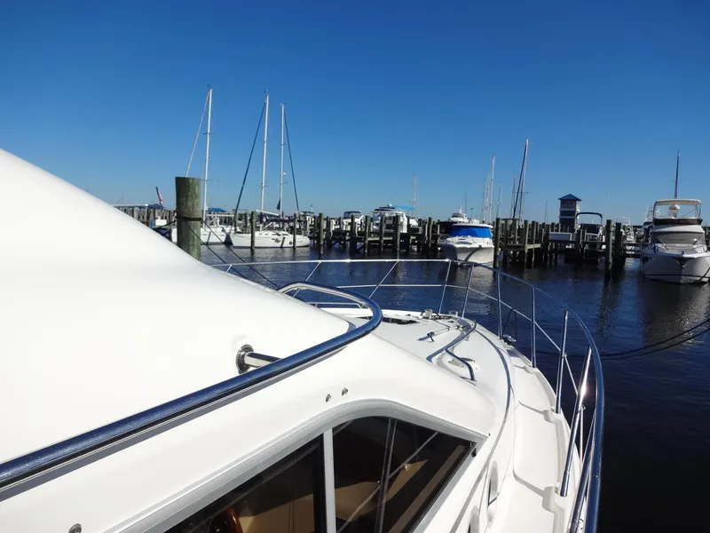 Slide: The Image of 1999 Sealine F44 yacht docked at a marina under a clear blue sky. - 13
