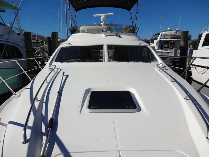 Slide: The Image of 1999 Sealine F44 yacht docked at marina, showcasing sleek design and spacious deck. - 15