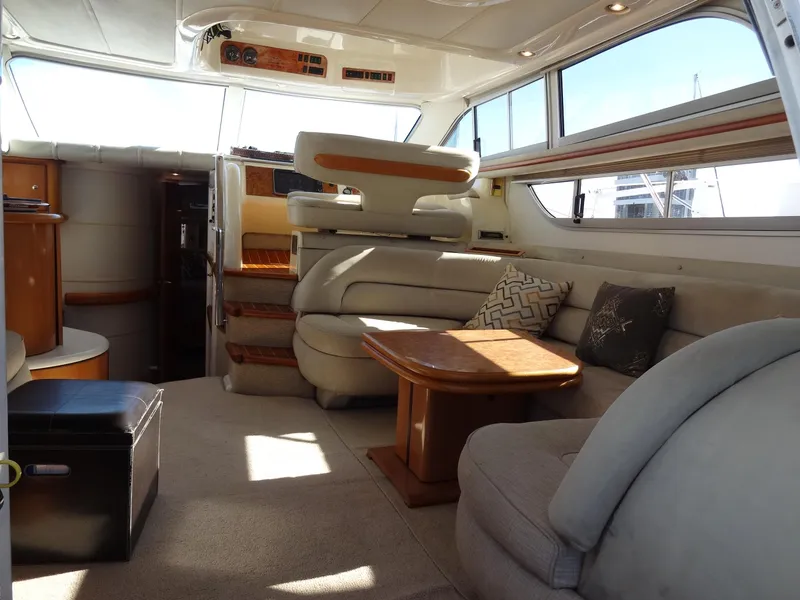 Slide: The Image of Interior of 1999 Sealine F44 yacht with plush seating and wooden table. - 22