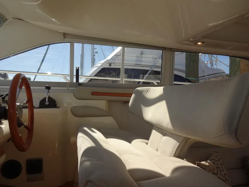 Slide: The Image of Interior of a 1999 Sealine F44 yacht with beige seating and wooden steering wheel. - 33