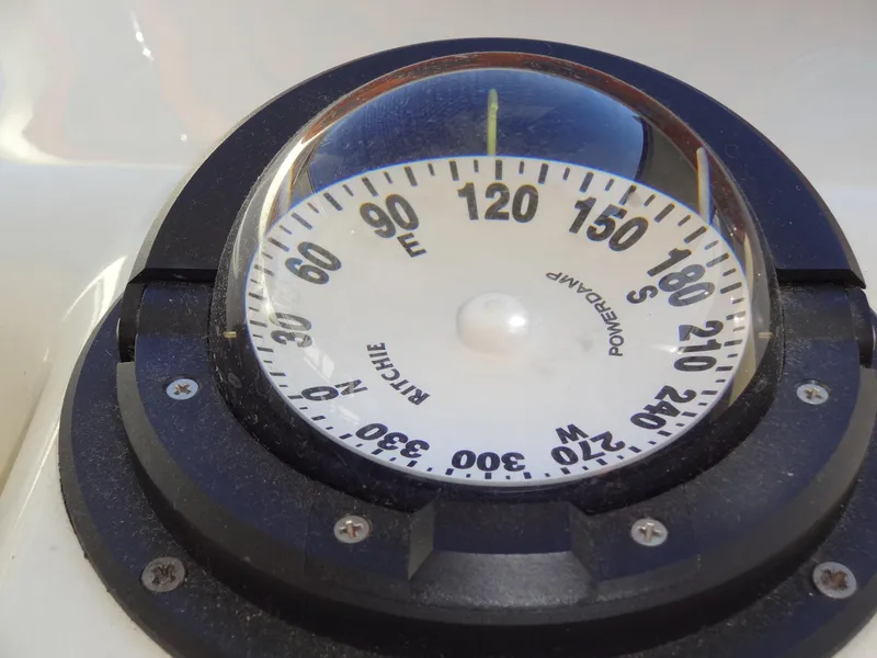 Slide: The Image of Compass on a 1999 Sealine F44 boat, displaying cardinal directions. - 39