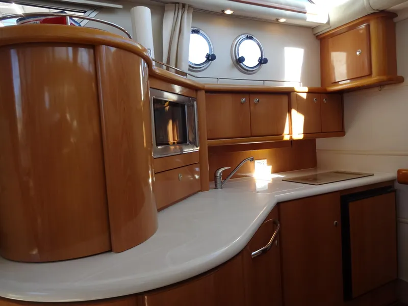 Slide: The Image of 1999 Sealine F44 yacht kitchen interior with wooden cabinets and modern appliances. - 42