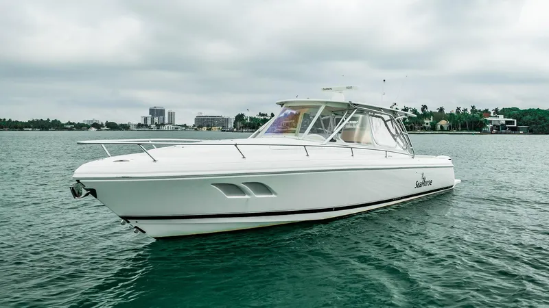 Slide: The Image of 2016 Intrepid 400 Cuddy boat on calm water under cloudy sky. - 15
