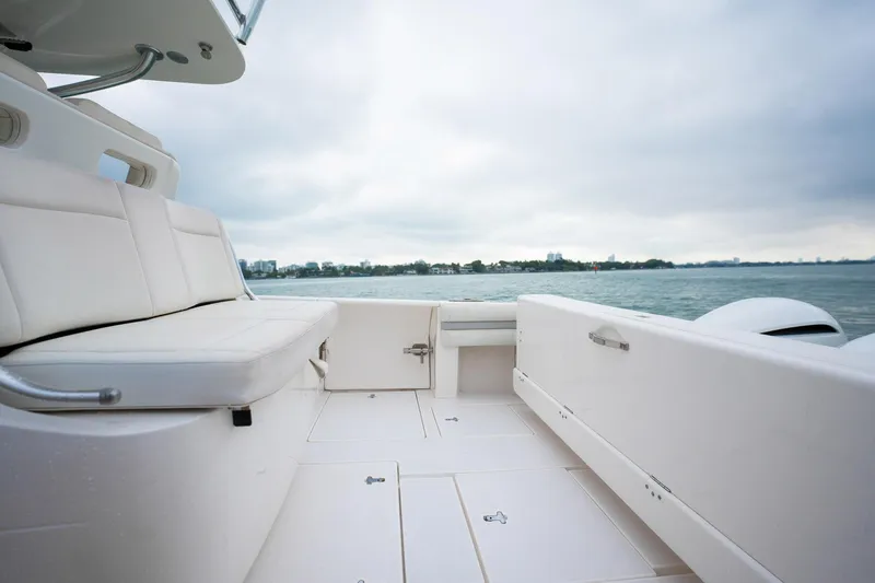 Slide: The Image of 2016 Intrepid 400 Cuddy boat interior with white seating, overlooking calm waters. - 27