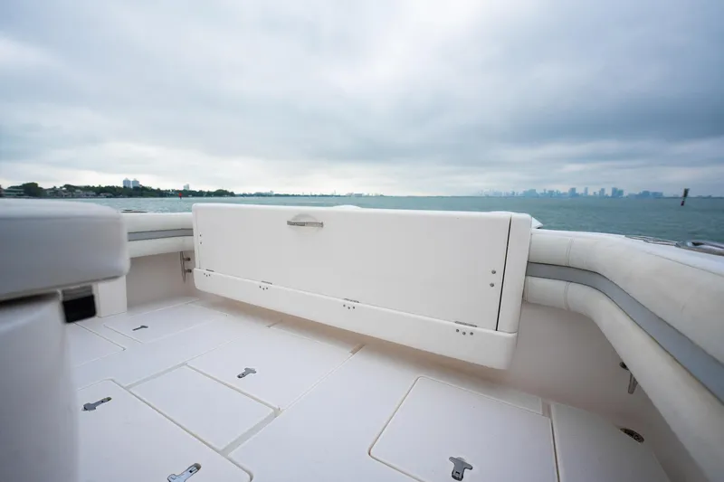 Slide: The Image of 2016 Intrepid 400 Cuddy boat deck with storage, overlooking a calm sea and cloudy sky. - 28