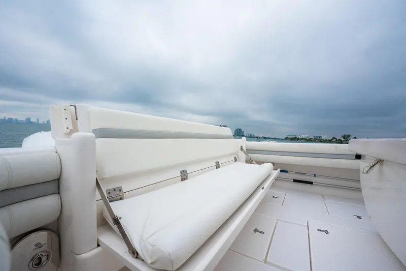 Slide: The Image of 2016 Intrepid 400 Cuddy boat interior with white seating, under a cloudy sky. - 30