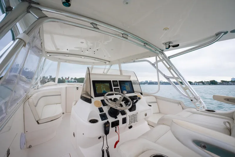 Slide: The Image of 2016 Intrepid 400 Cuddy boat interior with modern helm, dual screens, and comfortable seating. - 32