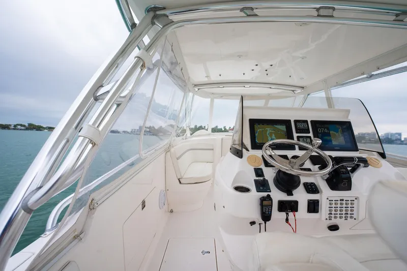 Slide: The Image of 2016 Intrepid 400 Cuddy helm with modern navigation equipment and steering wheel, overlooking the water. - 33