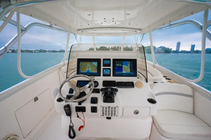 Slide: The Image of 2016 Intrepid 400 Cuddy helm with navigation screens, steering wheel, and ocean view. - 36