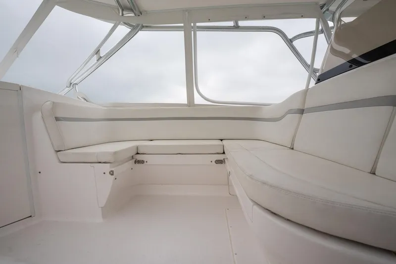 Slide: The Image of 2016 Intrepid 400 Cuddy interior with white cushioned seating and large windows. - 39