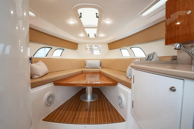 Slide: The Image of 2016 Intrepid 400 Cuddy interior with cozy seating and wooden table. - 44