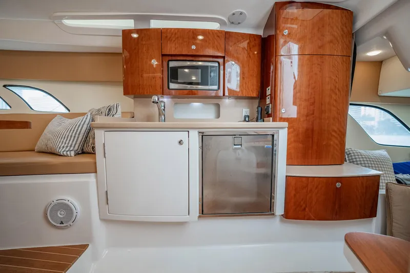 Slide: The Image of Interior of 2016 Intrepid 400 Cuddy yacht with kitchenette and seating area. - 45