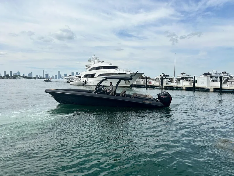 Slide: The Image of 2025 Skipper-BSK 34 boat cruising near marina with city skyline in background. - 16
