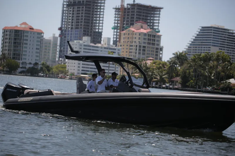 Slide: The Image of 2025 Skipper-BSK 34 boat cruising near urban waterfront with skyscrapers in background. - 8