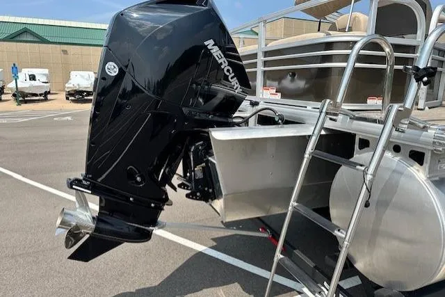 Slide: The Image of 2023 Sun Tracker SportFish 22 XP3 with Mercury outboard motor and ladder, parked outdoors. - 12