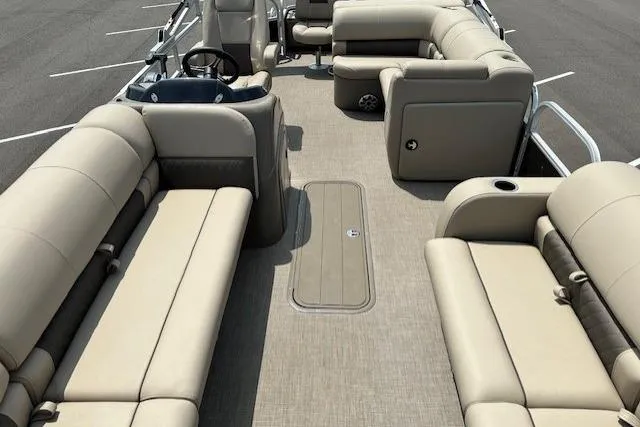 Slide: The Image of 2023 Sun Tracker SportFish 22 XP3 pontoon boat interior with beige seating and steering console. - 3