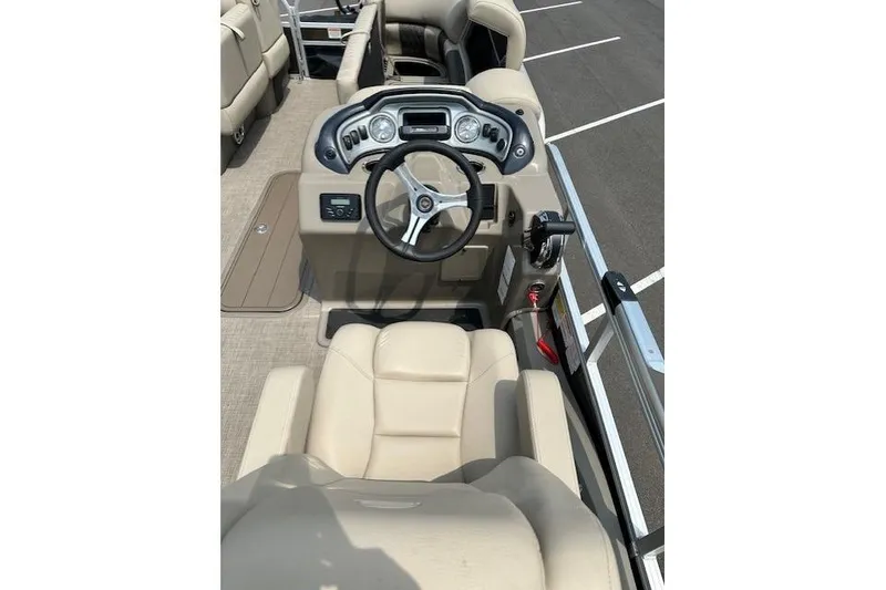 Slide: The Image of 2023 Sun Tracker SportFish 22 XP3 boat interior with steering console and beige seating. - 4