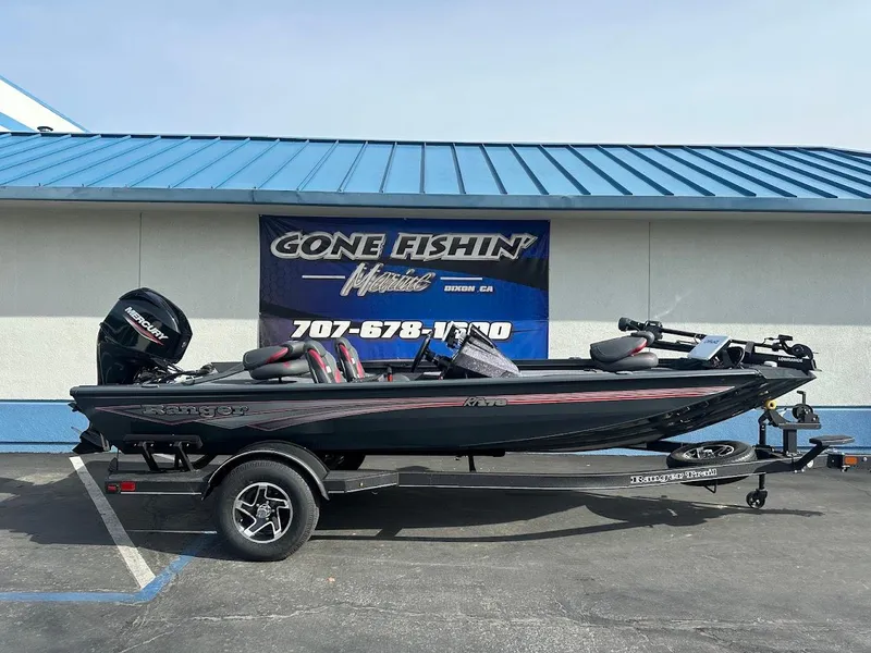 Slide: The Image of 2025 Ranger RT178 boat on trailer, parked outside a building with a blue roof. - 1